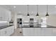 Modern kitchen boasts white cabinetry, stainless steel appliances, granite countertops, and pendant lighting at 2736 Sunrise Landing Ln, Lakeland, FL 33812