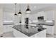 Modern kitchen boasts white cabinetry, stainless steel appliances, granite countertops, and pendant lighting at 2736 Sunrise Landing Ln, Lakeland, FL 33812