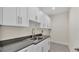 Bright laundry room features ample white cabinets, gray countertops and a stainless steel sink at 2736 Sunrise Landing Ln, Lakeland, FL 33812