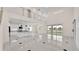 Bright and open-concept living space features a kitchen with an island, sleek tile floors, and high ceilings at 2736 Sunrise Landing Ln, Lakeland, FL 33812