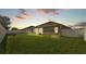 Large grassy backyard with a white fence and a neighboring house in the background at 2812 Whitney St, Lakeland, FL 33813