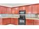 Well-equipped kitchen with cherry cabinets, granite countertops, and black appliances at 2812 Whitney St, Lakeland, FL 33813