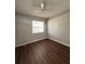 This cozy bedroom offers dark hardwood floors, a bright window and a ceiling fan at 29 Coleman Rd, Winter Haven, FL 33880
