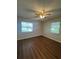 Bright bedroom with laminate floors, ceiling fan and two windows at 29 Coleman Rd, Winter Haven, FL 33880