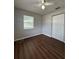 This bedroom offers a closet, window for natural light and dark hardwood floors at 29 Coleman Rd, Winter Haven, FL 33880