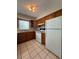 Traditional kitchen featuring wood cabinets, tiled floors, and standard white appliances at 29 Coleman Rd, Winter Haven, FL 33880