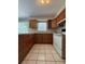 Traditional kitchen featuring wood cabinets, tiled floors, and standard white appliances at 29 Coleman Rd, Winter Haven, FL 33880