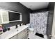 Modern bathroom with a vanity sink, a decorative mirror and a shower with black and white shower curtain at 3015 Thornhill Rd, Winter Haven, FL 33880