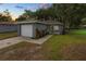 Charming single-story home with a one-car garage and a well-maintained front yard at sunset at 3015 Thornhill Rd, Winter Haven, FL 33880