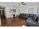 Bright living room with hardwood floors, a comfy couch, a ceiling fan, and a mounted television at 3015 Thornhill Rd, Winter Haven, FL 33880