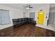 Spacious living room with hardwood floors, a ceiling fan, and a bright yellow front door at 3015 Thornhill Rd, Winter Haven, FL 33880
