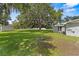Expansive backyard featuring a large, mature tree that provides ample shade, next to the house and shed at 3560 Sandpiper Ln, Mulberry, FL 33860