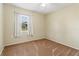 This bedroom features a window with white curtains and neutral carpeting at 3560 Sandpiper Ln, Mulberry, FL 33860