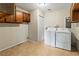 Spacious laundry room offers tile flooring, washer, dryer, and wooden cabinets at 3560 Sandpiper Ln, Mulberry, FL 33860