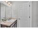 Well-lit bathroom featuring granite countertops, a vanity with a sink, and a decorative mirror at 3739 Peregrine Way, Lakeland, FL 33811