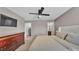 Calm bedroom features a ceiling fan, a flat-screen TV, dresser, and entry to closet and bathroom at 3739 Peregrine Way, Lakeland, FL 33811