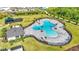 Aerial view of a lovely community pool with a splash pad, a playground, and well-manicured landscaping at 3739 Peregrine Way, Lakeland, FL 33811