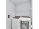 Efficient laundry room with modern washer and dryer units and a storage shelf at 3739 Peregrine Way, Lakeland, FL 33811