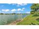 Picturesque view of a calm pond surrounded by lush greenery and clear blue skies at 3739 Peregrine Way, Lakeland, FL 33811