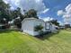 Well-manicured lawn, palm trees and front exterior, create a welcoming curb appeal at 3780 Pioneer Trails St, Lakeland, FL 33810