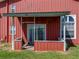 View of the covered back porch with sliding door and window of this red barn-style building at 4230 Viola Rd, Lakeland, FL 33810