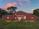 Back of the house with a rustic design and a lovely sunset backdrop at 4230 Viola Rd, Lakeland, FL 33810