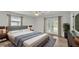 Bedroom with a bed, gray rug, wooden floors, ceiling fan, and access to the backyard through glass doors at 4622 Grovecrest Dr, Lakeland, FL 33813