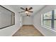 Spacious living room with wood-look tile flooring, two ceiling fans, and neutral walls at 4622 Grovecrest Dr, Lakeland, FL 33813
