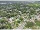Wide aerial shot of the home in a quiet neighborhood with well-maintained lawns and mature trees at 504 Prado Pl, Lakeland, FL 33803