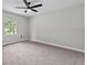 Bright carpeted bedroom with a ceiling fan, and window view offering natural light at 504 Prado Pl, Lakeland, FL 33803