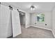 Cozy bedroom with carpet, stylish barn doors, a window and updated ceiling light fixture at 504 Prado Pl, Lakeland, FL 33803