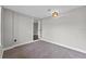 Carpeted bedroom with view to connecting room with wood floors; updated lighting fixture on ceiling at 504 Prado Pl, Lakeland, FL 33803