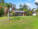 Single-story home boasts a large front yard, mature landscaping, and freshly painted facade at 504 Prado Pl, Lakeland, FL 33803