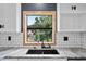 Granite countertops and tiled backsplash add a modern touch to the kitchen sink at 504 Prado Pl, Lakeland, FL 33803