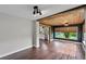 Open-concept room with wood-look floors, wood ceiling beams, and view into the kitchen at 504 Prado Pl, Lakeland, FL 33803