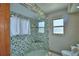 Bathroom boasting a decorative-tiled shower with glass door, bench seat and storage niche at 5313 Nichols W Dr, Lakeland, FL 33812
