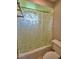 Bathroom with a white shower tub combination and a shower curtain with a flower and leaf pattern at 5313 Nichols W Dr, Lakeland, FL 33812