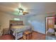 Bedroom with a bed, ceiling fan, and a small window, complemented by wood-look floors at 5313 Nichols W Dr, Lakeland, FL 33812