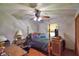 Bedroom with a ceiling fan and light fixture, a desk, a bed, and wood-look flooring at 5313 Nichols W Dr, Lakeland, FL 33812