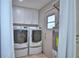 Well-equipped laundry room with modern washer, dryer, white cabinetry, and access door at 5313 Nichols W Dr, Lakeland, FL 33812