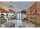 Spacious open concept living room with brick fireplace, tile floors, comfortable seating and view of kitchen at 5313 Nichols W Dr, Lakeland, FL 33812