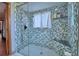 Walk-in shower featuring decorative tilework, glass enclosure and built-in shelves at 5313 Nichols W Dr, Lakeland, FL 33812