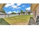 Large, fenced backyard with a well-maintained lawn, mature trees, and beautiful blooming flowers at 5548 Woodwind Hills Dr, Lakeland, FL 33812