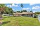 Aerial backyard view showcasing the lush lawn, white fence, screened lanai, and mature landscaping at 5548 Woodwind Hills Dr, Lakeland, FL 33812