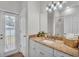 Bright bathroom featuring double sinks, granite countertops, and a walk-in shower at 5548 Woodwind Hills Dr, Lakeland, FL 33812