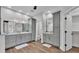 Bathroom featuring double vanities, stylish mirrors, and modern gray cabinetry at 5548 Woodwind Hills Dr, Lakeland, FL 33812