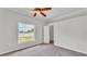 Bedroom featuring large window, carpet, ceiling fan, white walls, and white trim at 5548 Woodwind Hills Dr, Lakeland, FL 33812