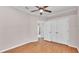 Bedroom with wood floors, closet, ceiling fan, white walls, and white trim at 5548 Woodwind Hills Dr, Lakeland, FL 33812
