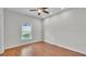 Bedroom featuring a window, wood floor, ceiling fan, white walls, and white trim at 5548 Woodwind Hills Dr, Lakeland, FL 33812