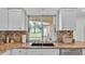 Kitchen with granite countertops, stainless steel sink, and view of fenced-in backyard at 5548 Woodwind Hills Dr, Lakeland, FL 33812